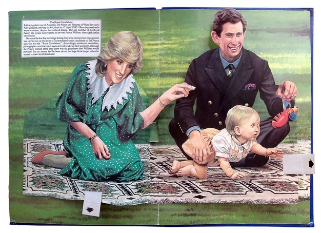 Pages of a book. The arms and faces of two pale-skinned people and a baby, Lady Diana, Prince Charles, and baby William, pop out in a colour illustration showing the family have a picnic on a grassy lawn.